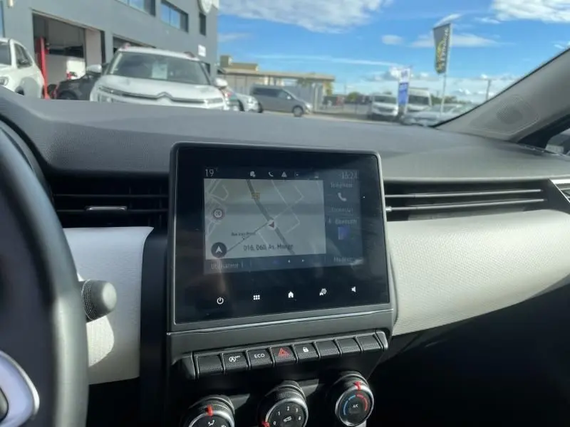 Tableau de bord de Renault Clio V TCE 90 X-TRONIC Evolution 2023, écran tactile avec navigation, ambiance claire intérieure.