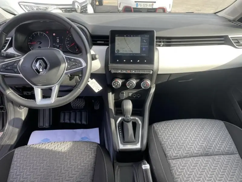 Vue intérieure avant de la Renault Clio V TCE 90 X-TRONIC Evolution 2023, tableau de bord gris clair avec écran tactile et volant multifonction.