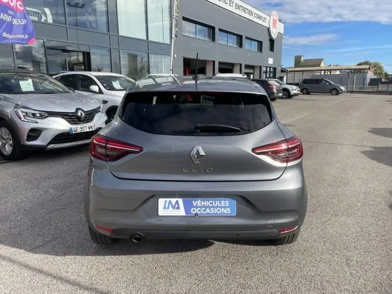 Vue arrière d'une Renault Clio V gris foncé métal 2023 avec vitres teintées et logo distinctif au centre du hayon.