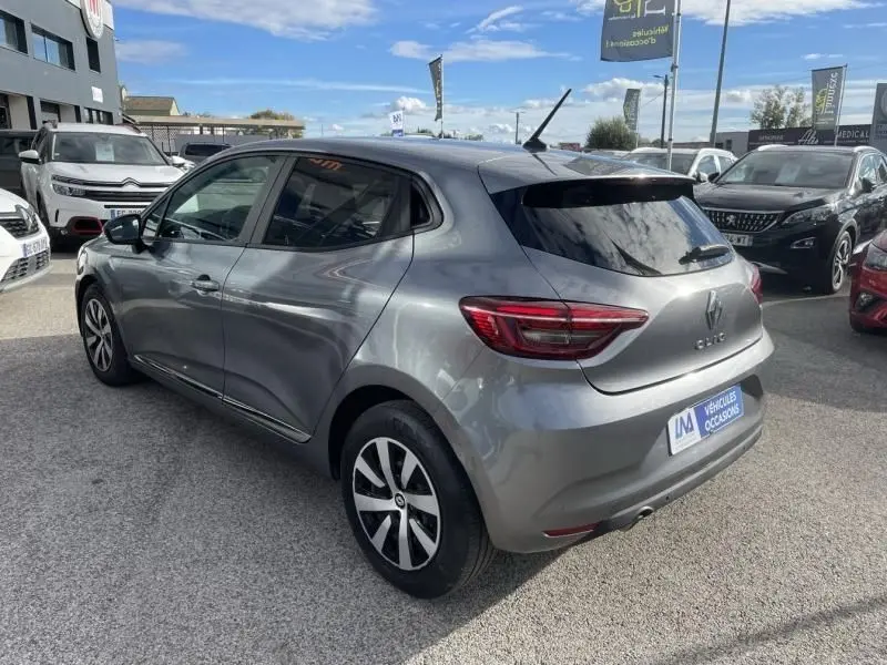 Vue 3/4 arrière droite d'une Renault Clio V gris foncé métal 2023 avec jantes alliage et vitres teintées.