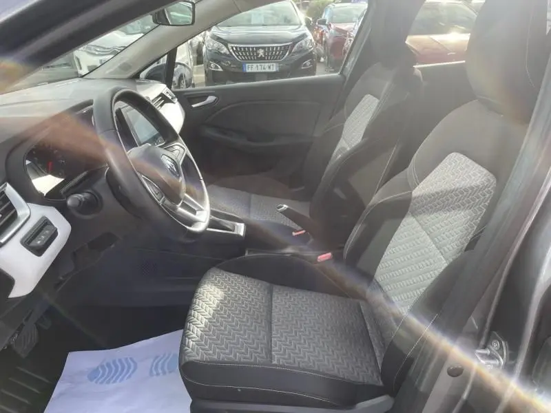 Vue intérieure côté conducteur de la Renault Clio V TCE 90 X-TRONIC Evolution 2023 avec sièges gris à motifs géométriques.