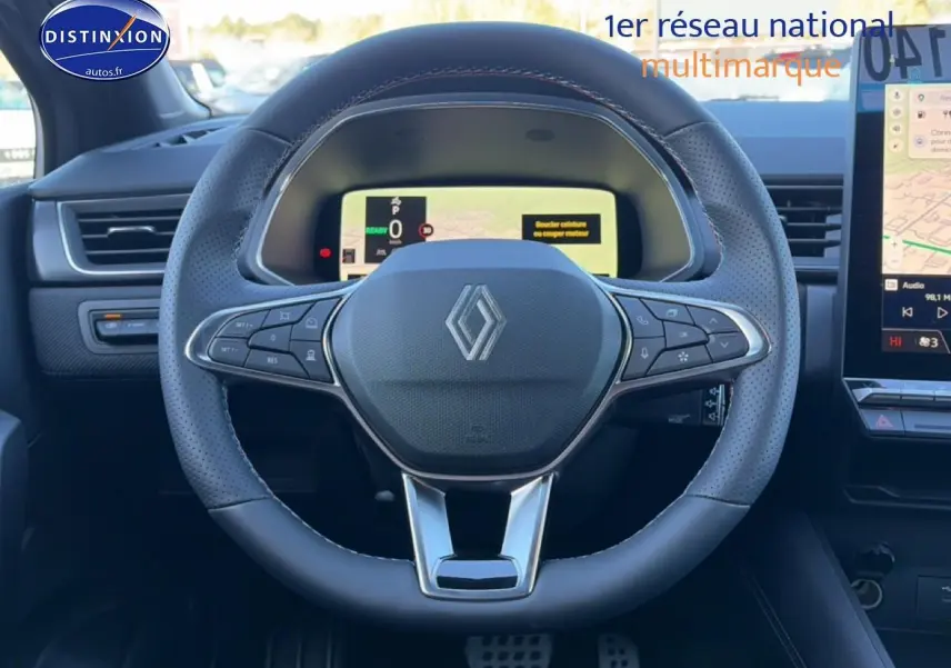 Vue intérieure centrée sur le volant cuir perforé du Renault Captur gris cassiopée avec tableau de bord numérique et écran tactile.