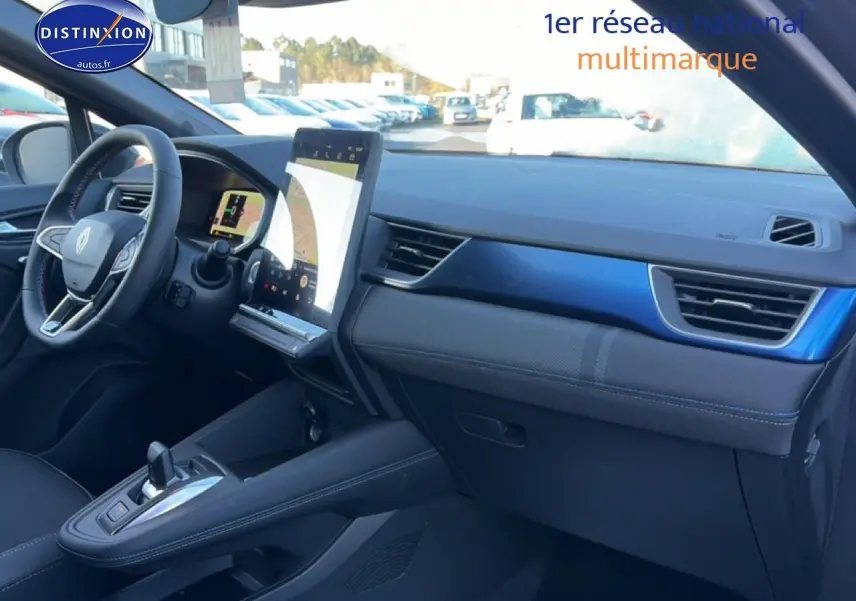 Vue intérieure côté passager du tableau de bord bleu et noir du Renault Captur 1.8 e-tech full hybrid 2025 avec écran tactile vertical.