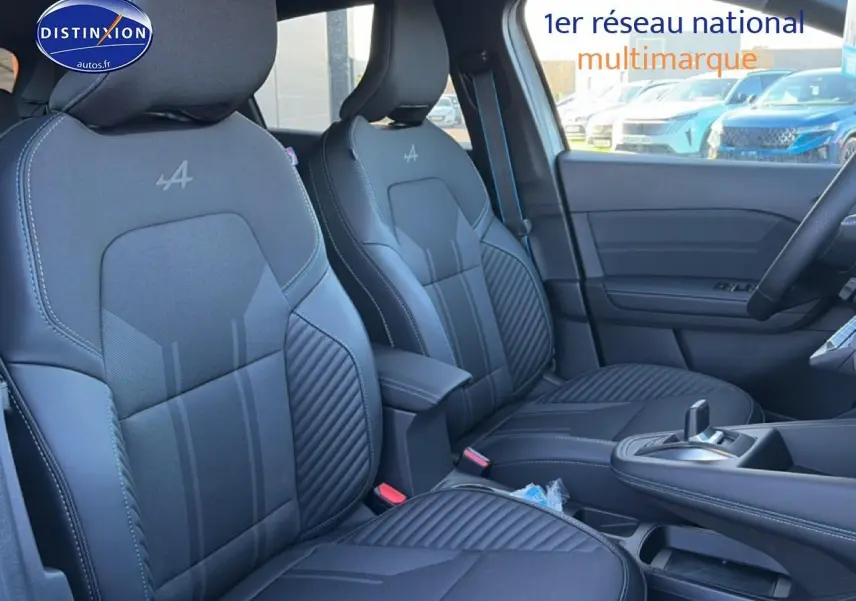 Vue intérieure côté avant droit des sièges noirs avec logo Alpine et accoudoir central du Renault Captur 2025 hybride.