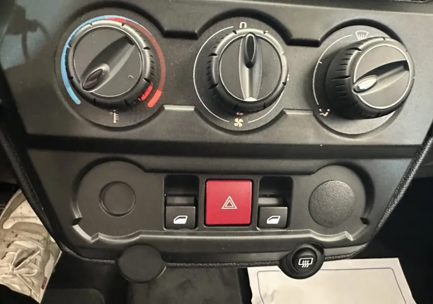 Gros plan sur les commandes de climatisation et les boutons de l’AIXAM AMBITION 0.5 CITY PACK 2026, intérieur noir.