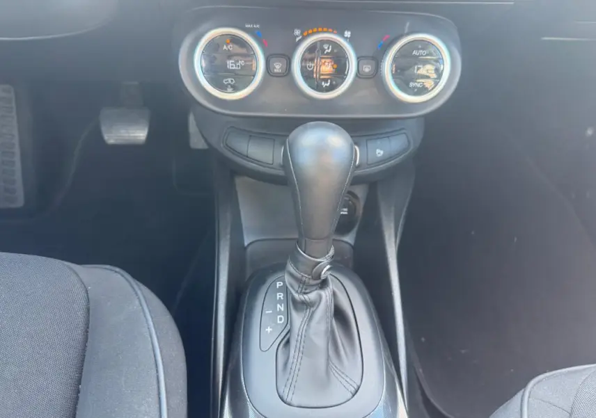 Le levier de vitesse automatique et les commandes de climatisation manuelle du Fiat 500X bleu, vue intérieure centrée.