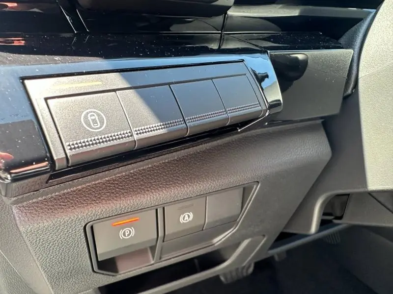 Détail intérieur côté conducteur du Renault Austral blanc nacré, montrant les commandes de verrouillage et frein de stationnement.
