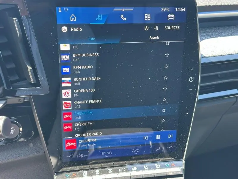 Écran tactile central du Renault Austral blanc nacré, affichant la liste des radios DAB en intérieur.