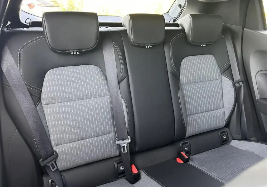 Vue arrière intérieure des sièges arrière gris et noirs de la Renault Clio V TCE 90 Techno 2025, avec ceintures attachées.