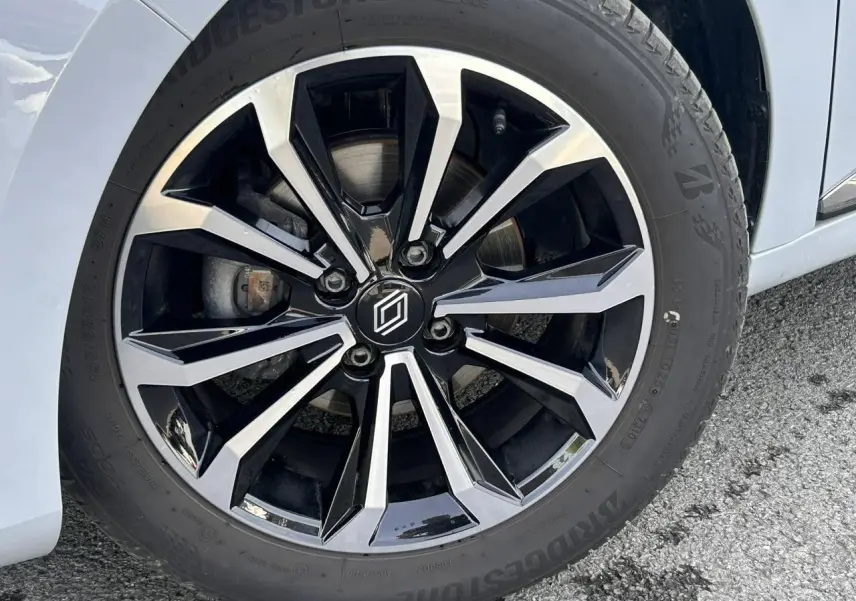 Gros plan sur la jante alliage diamantée 16 pouces noire et argentée de la Renault Clio Gris Rafale côté droit.
