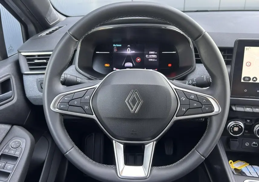 Vue rapprochée du volant multifonction noir et du tableau de bord numérique de la Renault Clio 2025.