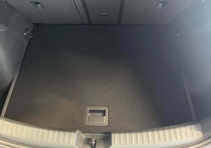 Coffre ouvert vu de dessus de la CUPRA Leon gris, montrant un espace de chargement propre et vide.