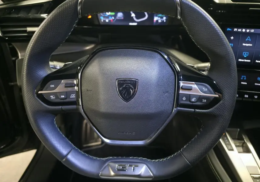 Volant cuir noir de Peugeot 308 SW GT 2024 avec logo lion et badge GT en vue frontale rapprochée.