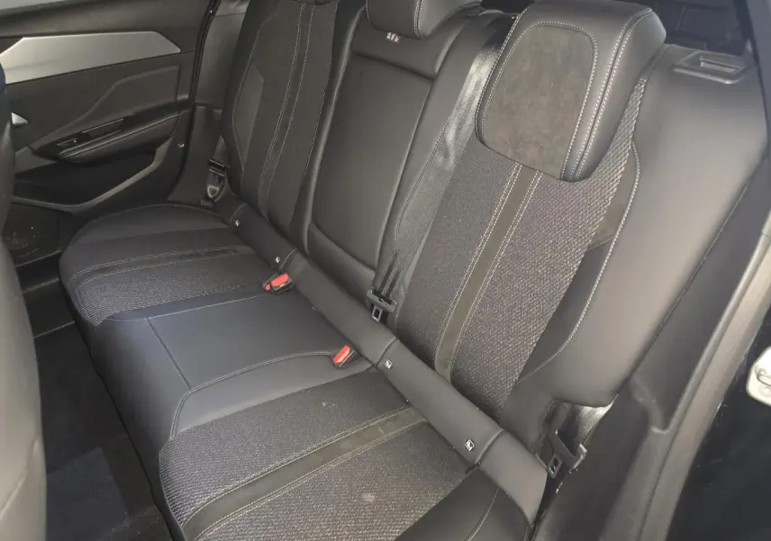 Vue intérieure des sièges arrière en cuir noir et tissu de la Peugeot 308 SW GT hybride rechargeable 2024.