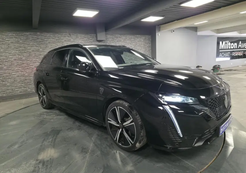 Peugeot 308 SW GT noire vue en 3/4 avant droit, avec feux LED et jantes alliage 18 pouces distinctives.