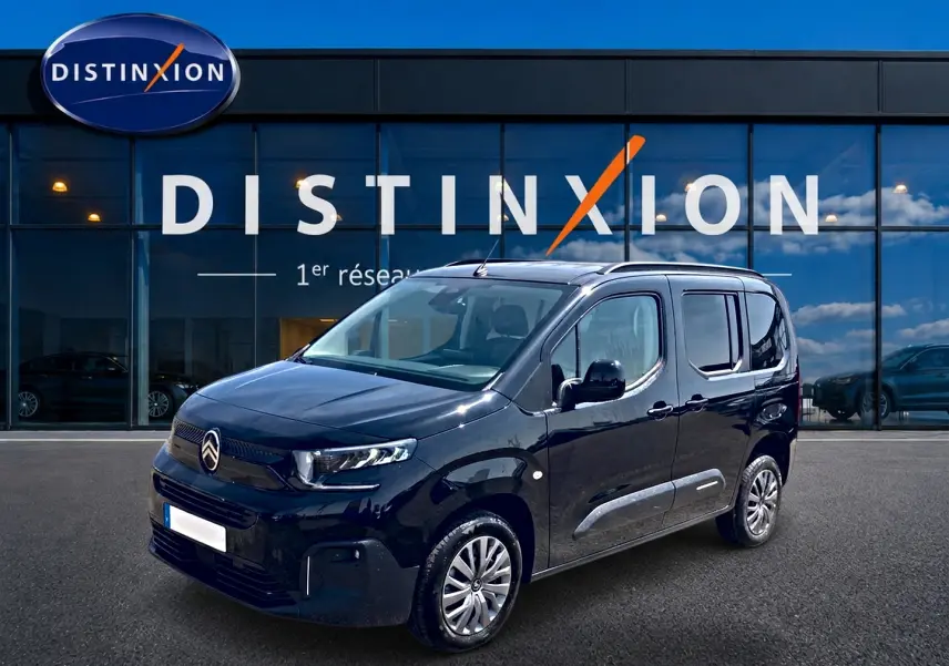 Citroën Berlingo noir vue 3/4 avant droit, avec barres de toit et poignées ton carrosserie visibles.