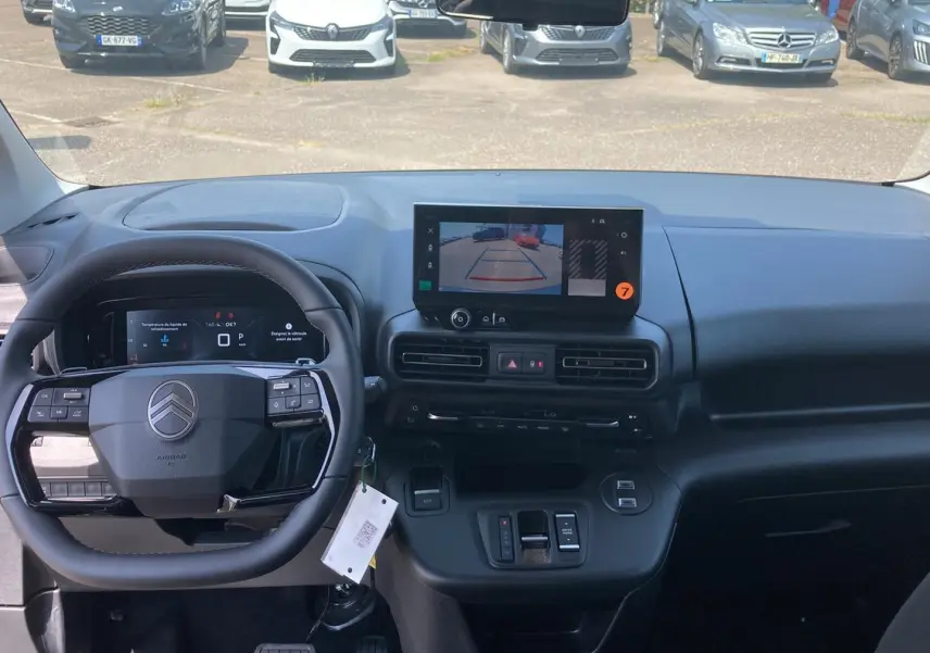 Vue intérieure avant du Citroën Berlingo noir 2026, volant multifonction et écran tactile affichant la caméra de recul.