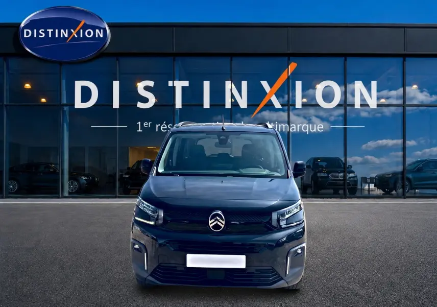 Vue avant d'un Citroën Berlingo noir 2026 avec phares LED et barres de toit, devant une vitrine Distinxion.