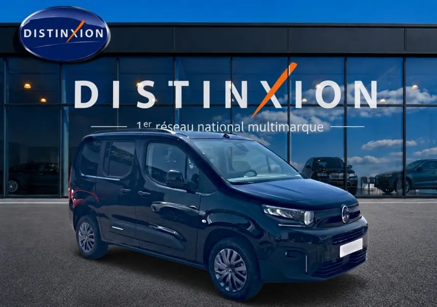 Vue 3/4 avant droite d'un Citroën Berlingo noir 2026 garé devant une vitrine avec logo Distinxion.