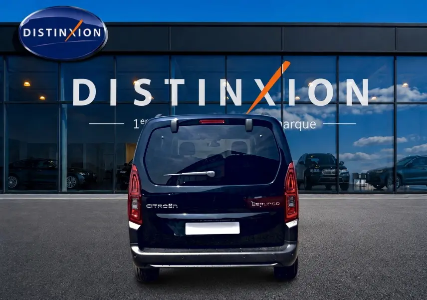 Vue arrière d'un Citroën Berlingo noir 2026 garé devant une vitrine avec logo Distinxion.