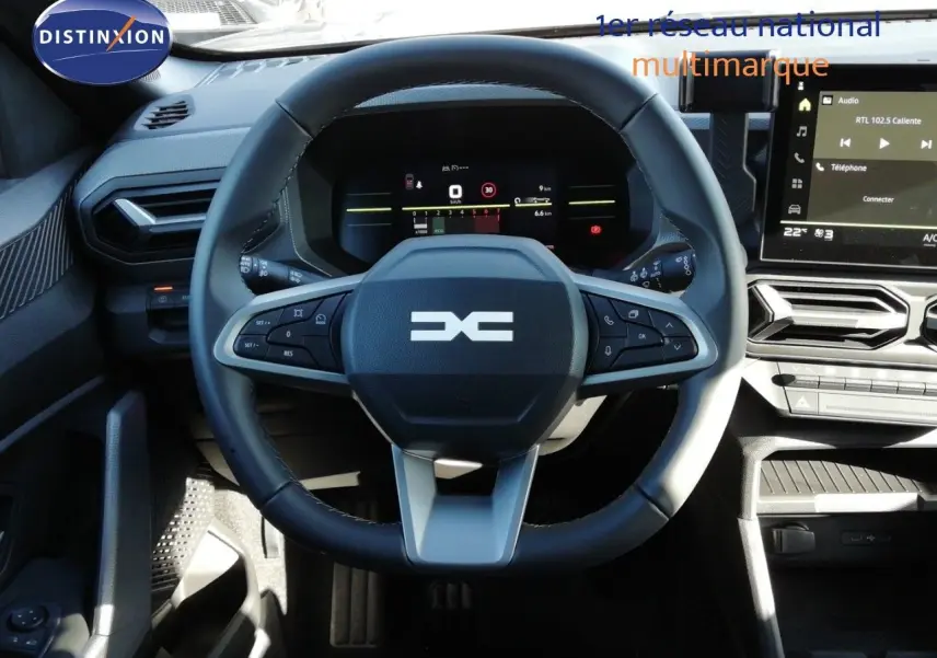 Vue rapprochée du volant noir et gris du Dacia Duster 2026 TCE MHEV 140CH Journey avec tableau de bord digital et écran central.