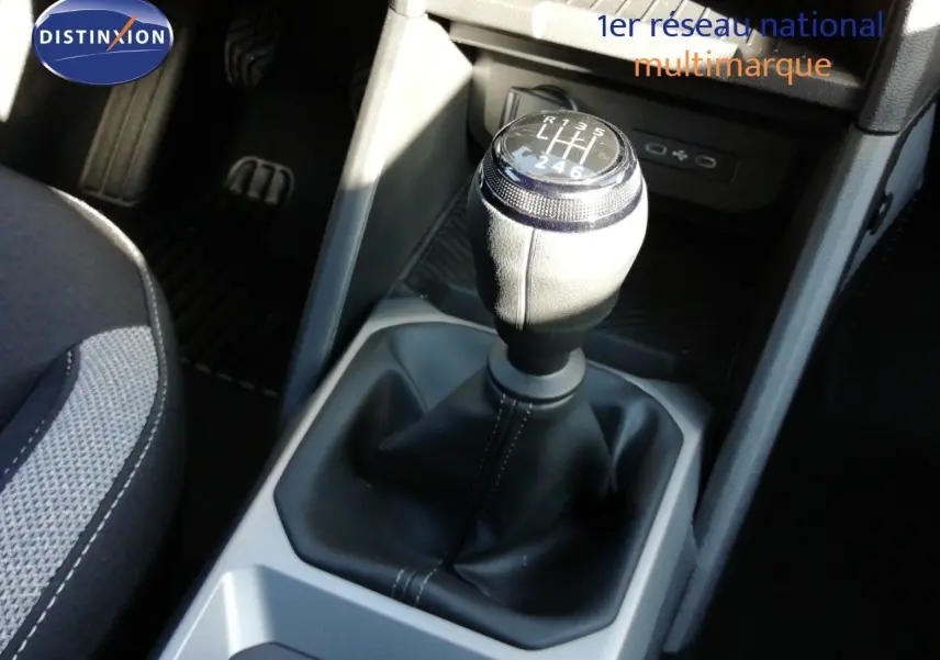 Gros plan sur le levier de vitesses manuel du Dacia Duster gris schiste, avec sellerie tissu noir et gris visible.