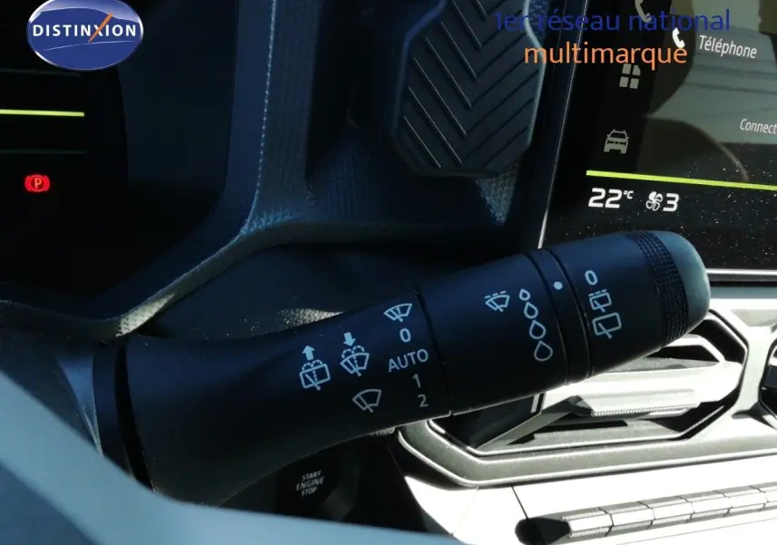 Gros plan sur la commande des essuie-glaces dans l’habitacle du Dacia Duster gris schiste métal, avec écran tactile en arrière-plan.