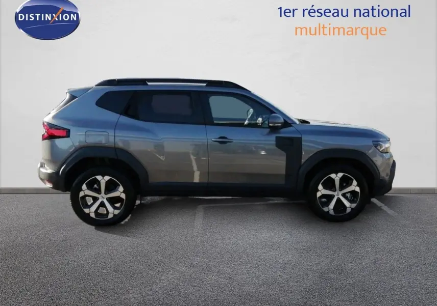 Profil droit du Dacia Duster TCE MHEV 140ch Journey gris schiste métal avec jantes bi-ton et protections noires.