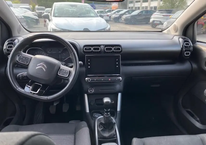 Intérieur noir du Citroën C3 Aircross 2019, vue frontale du tableau de bord avec volant multifonction et boîte manuelle.