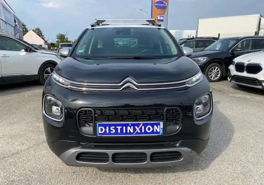 Vue de face d'un Citroën C3 Aircross noir 2019 avec toit blanc et barres de toit sur un parking.