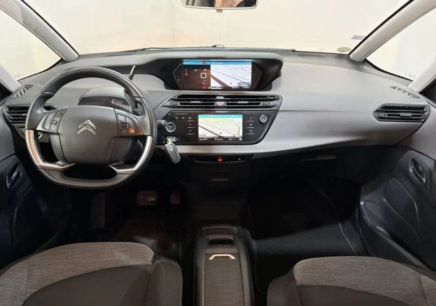 Vue intérieure avant du tableau de bord gris et noir du Citroën Grand C4 Spacetourer avec double écran tactile et volant multifonction.