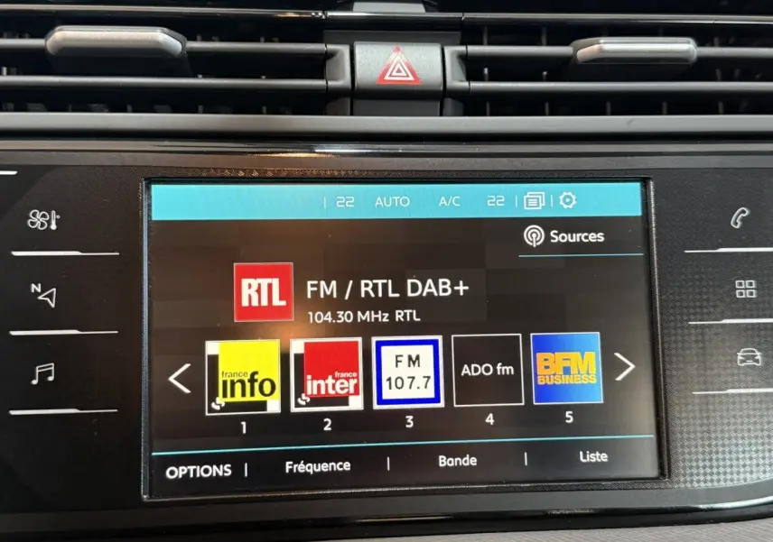 Écran tactile central de la Citroën Grand C4 Spacetourer blanc, affichant les stations radio FM avec commandes tactiles.