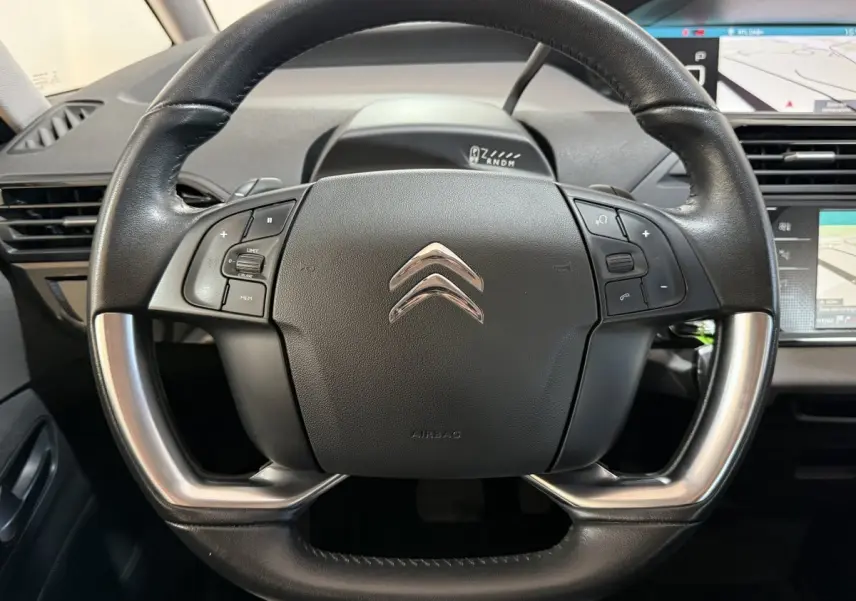 Vue rapprochée du volant cuir et alu noir du Citroën Grand C4 Spacetourer avec commandes intégrées et tableau de bord numérique.