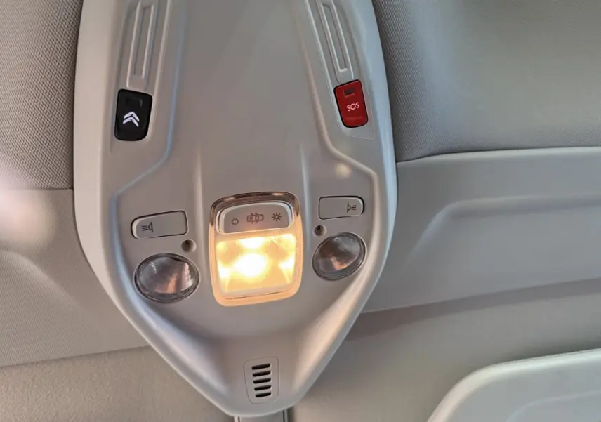 Vue rapprochée du plafonnier gris clair avec éclairage et boutons SOS et assistance du Citroën Grand C4 Spacetourer blanc.