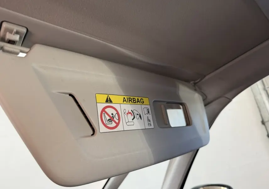 Gros plan sur le pare-soleil intérieur côté conducteur du Citroën Grand C4 Spacetourer blanc avec avertissement airbag visible.