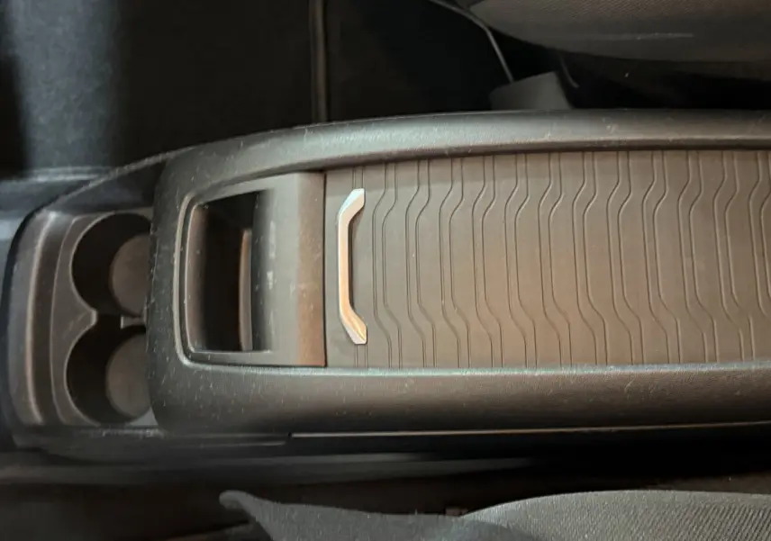 Gros plan sur la console centrale noire du Citroën Grand C4 Spacetourer avec porte-gobelets et rangement coulissant.