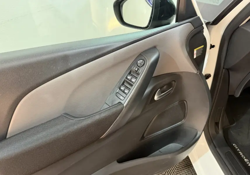 Intérieur côté conducteur du Citroën Grand C4 Spacetourer blanc 2021, avec panneau de porte noir et gris et commandes électriques.