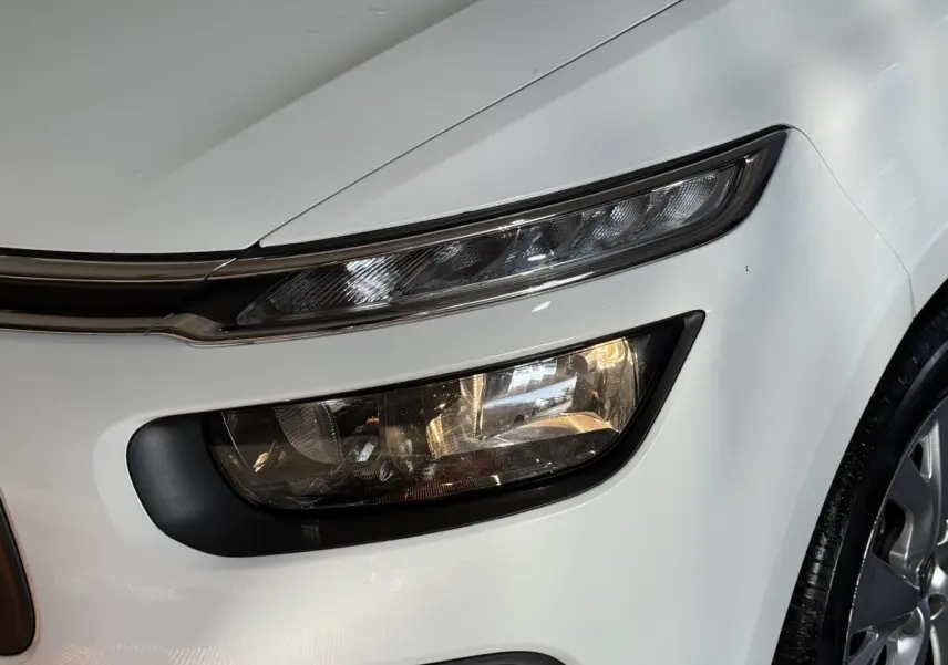 Gros plan sur le phare avant droit blanc du Citroën Grand C4 Spacetourer 2021 avec détails du feu et partie de la roue.