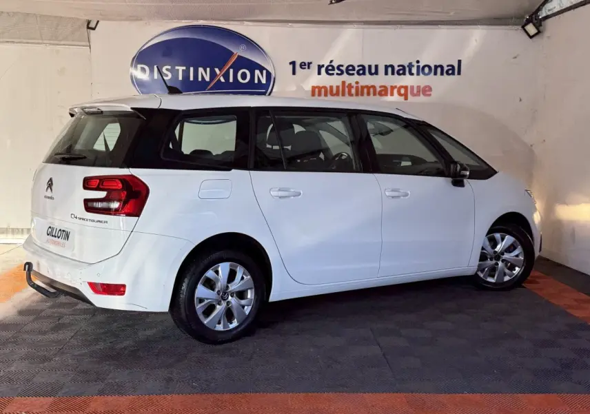 Vue 3/4 arrière droite d'un Citroën Grand C4 Spacetourer blanc, avec feux arrière distinctifs et jantes alliage.