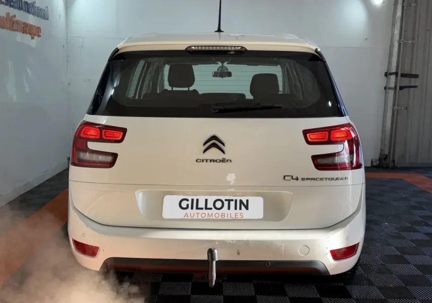 Vue arrière d'un Citroën Grand C4 Spacetourer blanc avec feux allumés et attelage visible en intérieur.