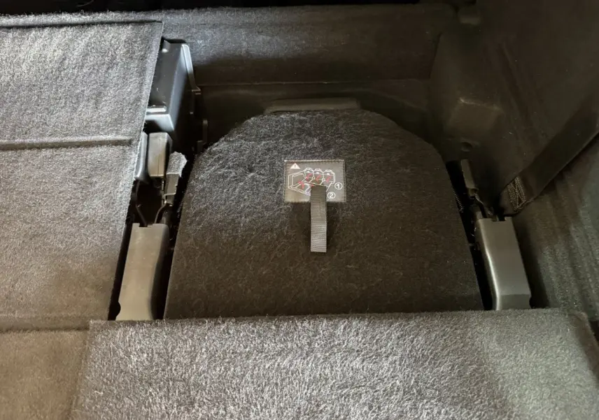 Vue rapprochée du plancher plat noir avec siège individuel rabattable du coffre du Citroën Grand C4 Spacetourer blanc.