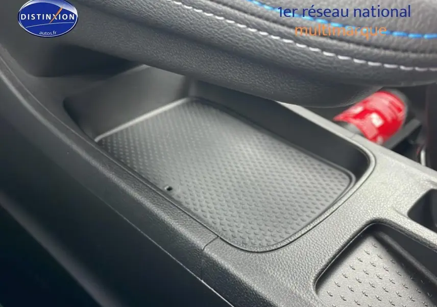 Gros plan sur le rangement central noir avec surpiqûres bleues du Renault Captur 1.8 e-tech hybride 2025 esprit Alpine.