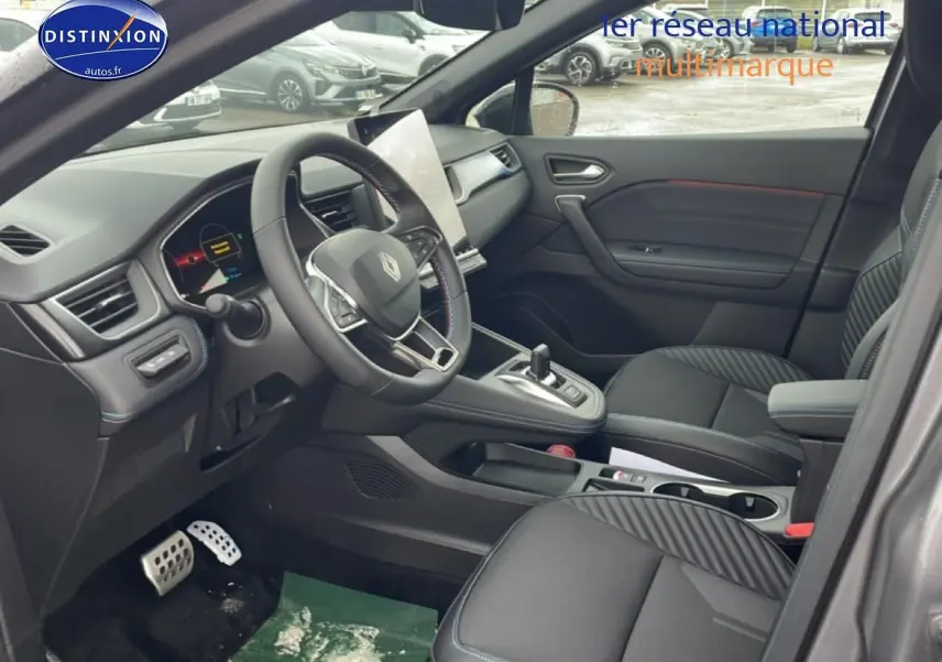 Vue intérieure côté conducteur du Renault Captur gris cassiopée, volant cuir multifonction et écran tactile vertical.