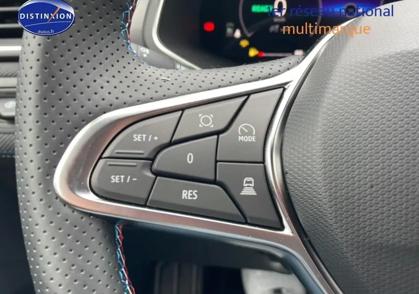 Gros plan sur les commandes multifonctions à gauche du volant cuir perforé du Renault Captur gris cassiopée 2025 esprit alpine.