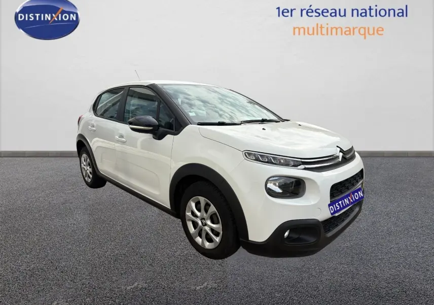 Citroën C3 blanc vue 3/4 avant droit, avec détails noirs contrastants sur les rétroviseurs et protections basses.