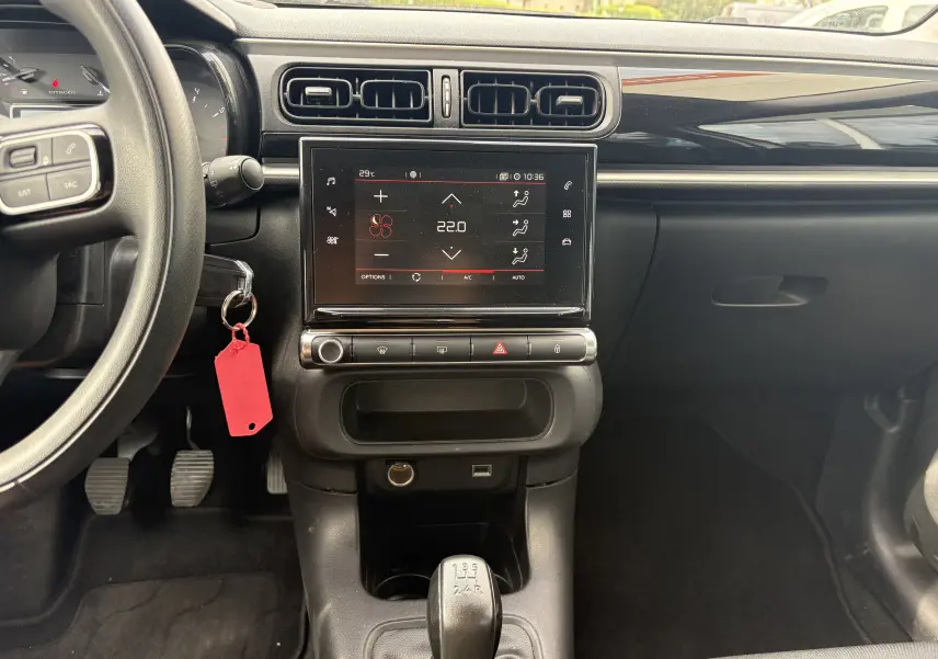 Vue intérieure centrée sur la console centrale d'une Citroën C3 blanche 2019 avec écran tactile et boîte manuelle.
