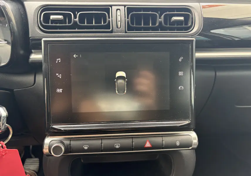 Vue rapprochée de la console centrale noire d’une Citroën C3 blanche 2019 avec écran tactile et commandes climatisation.