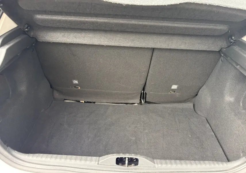Vue intérieure du coffre noir de la Citroën C3 2019, version 1.2 82 Feel, montrant les sièges arrière rabattus.