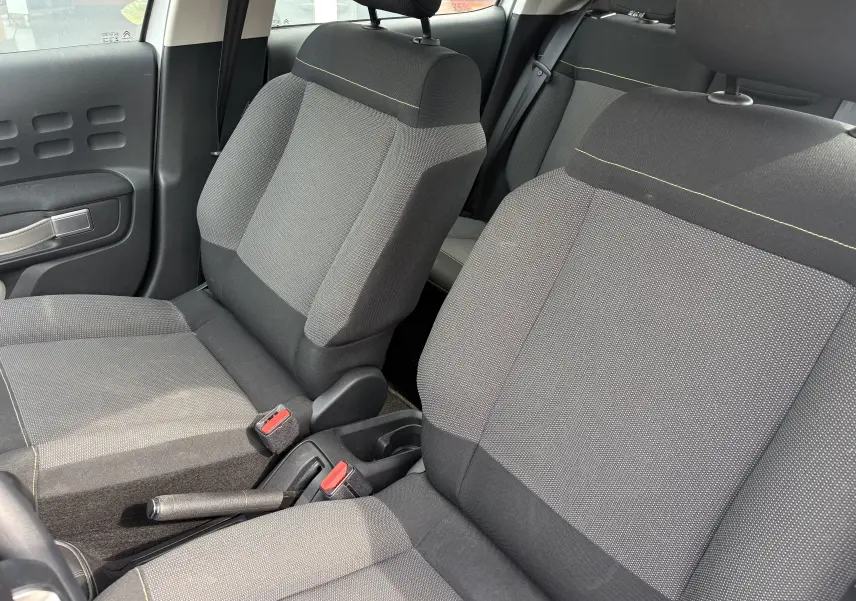 Vue intérieure rapprochée des sièges avant gris foncé et clair du Citroën C3 2019, avec détails de couture jaune.
