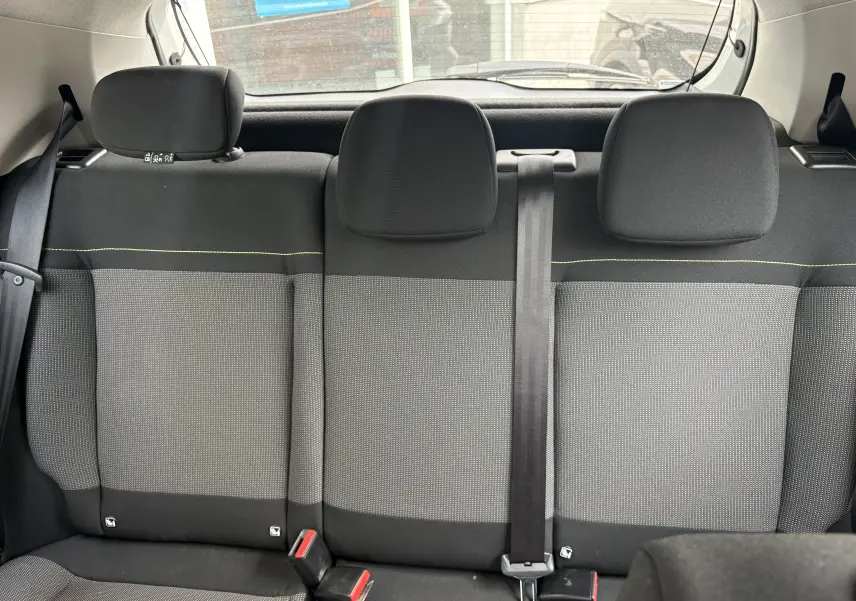 Vue intérieure arrière des sièges arrière gris et noir de la Citroën C3 blanche de 2019 avec ceinture centrale visible.